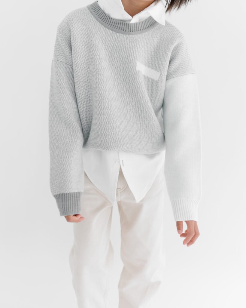 Child wearing the grey Tres London Chelsea jumper over a white shirt and trousers